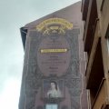 Werbeschild vor historischer Fassade, da würde in Dresden der Denkmalschutz aber zu Recht auf die Barrikaden gehen.